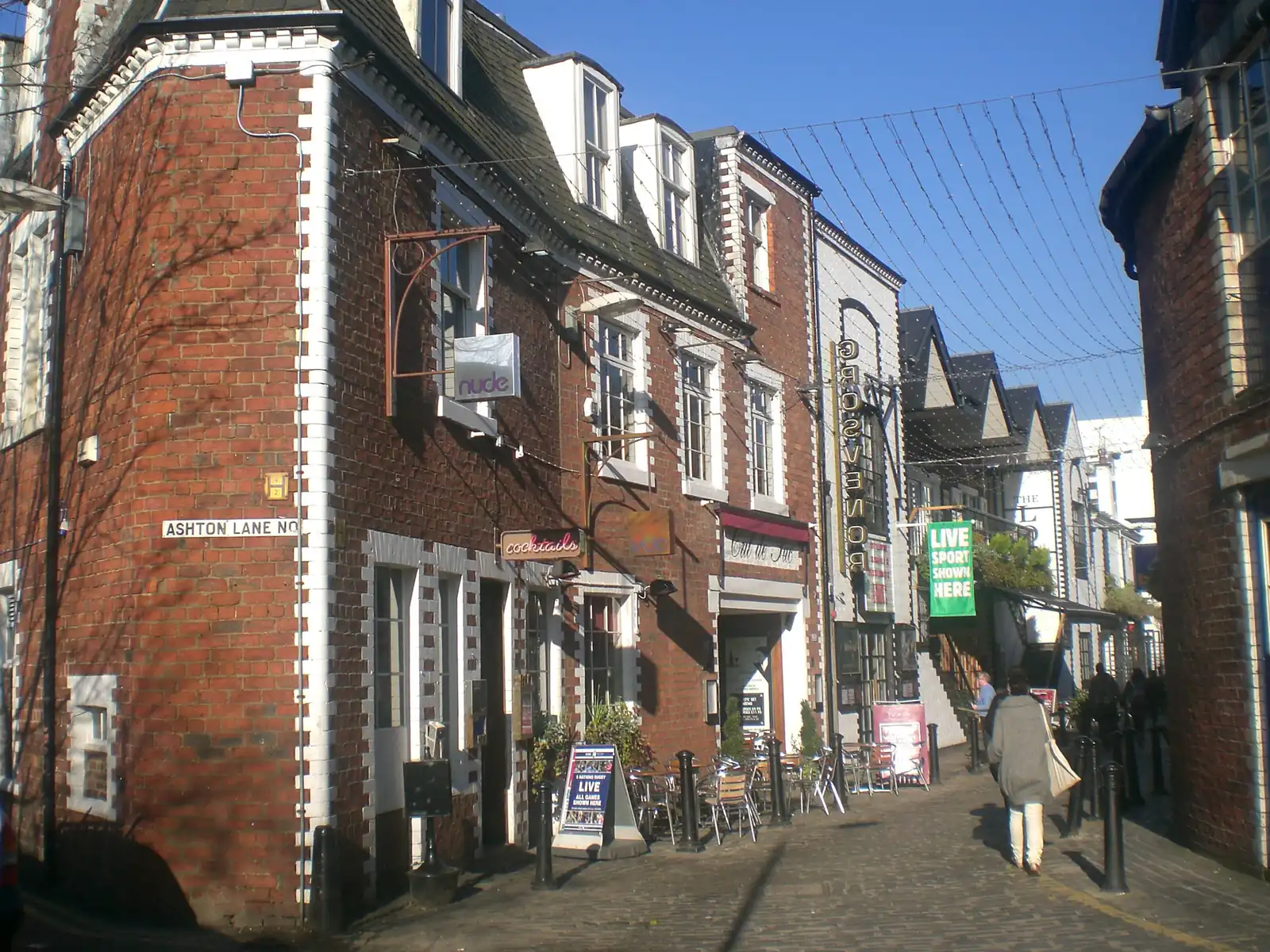 Cobbled Ashton Lane in Hillhead, Glasgow West End, lined with bars and restaurants on a sunny day